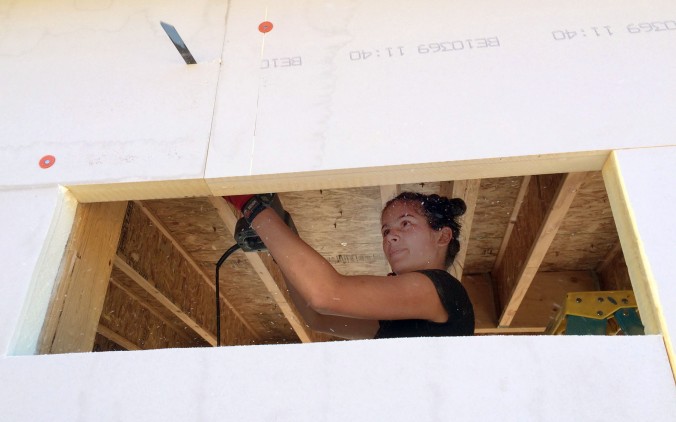 E. cutting out the windows with a reciprocating saw after covering them with exterior Polyiso foam.